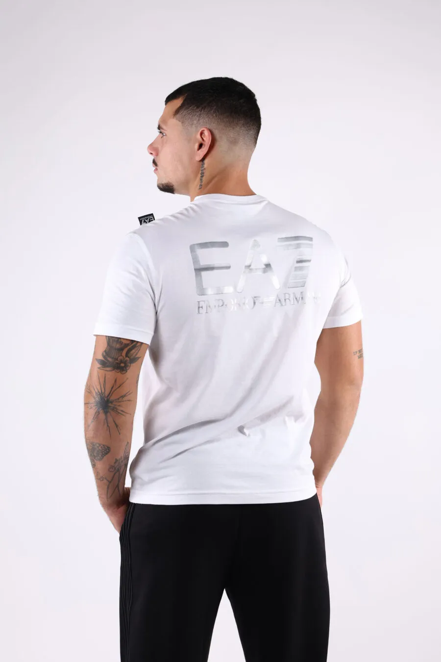 Camiseta blanca con maxilogo plateado detrás